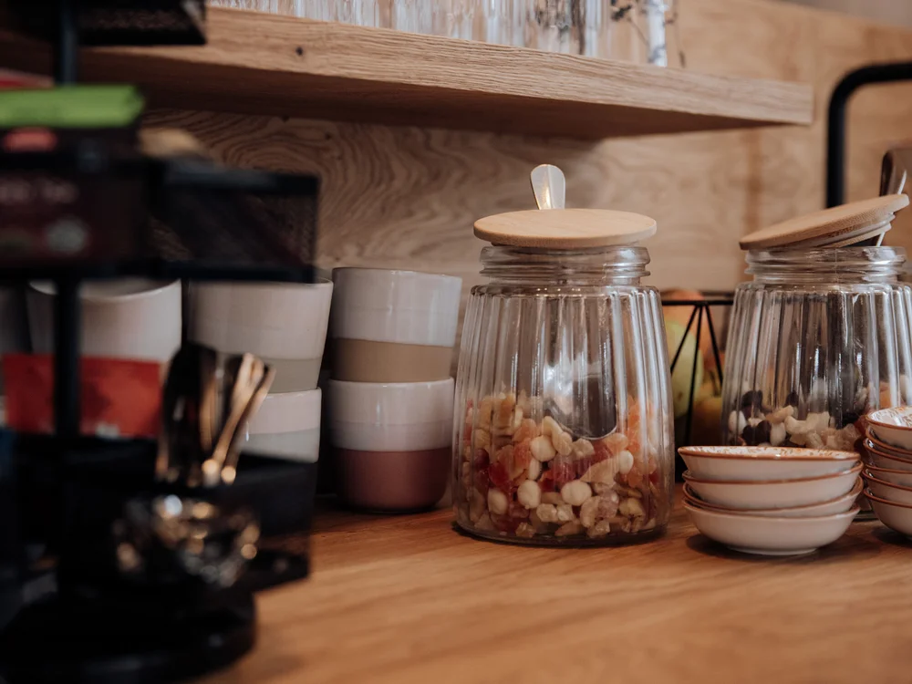 Winterurlaub beim Forstauerwirt Gläser mit Müsli und gestapelte Schalen auf einer Holztheke