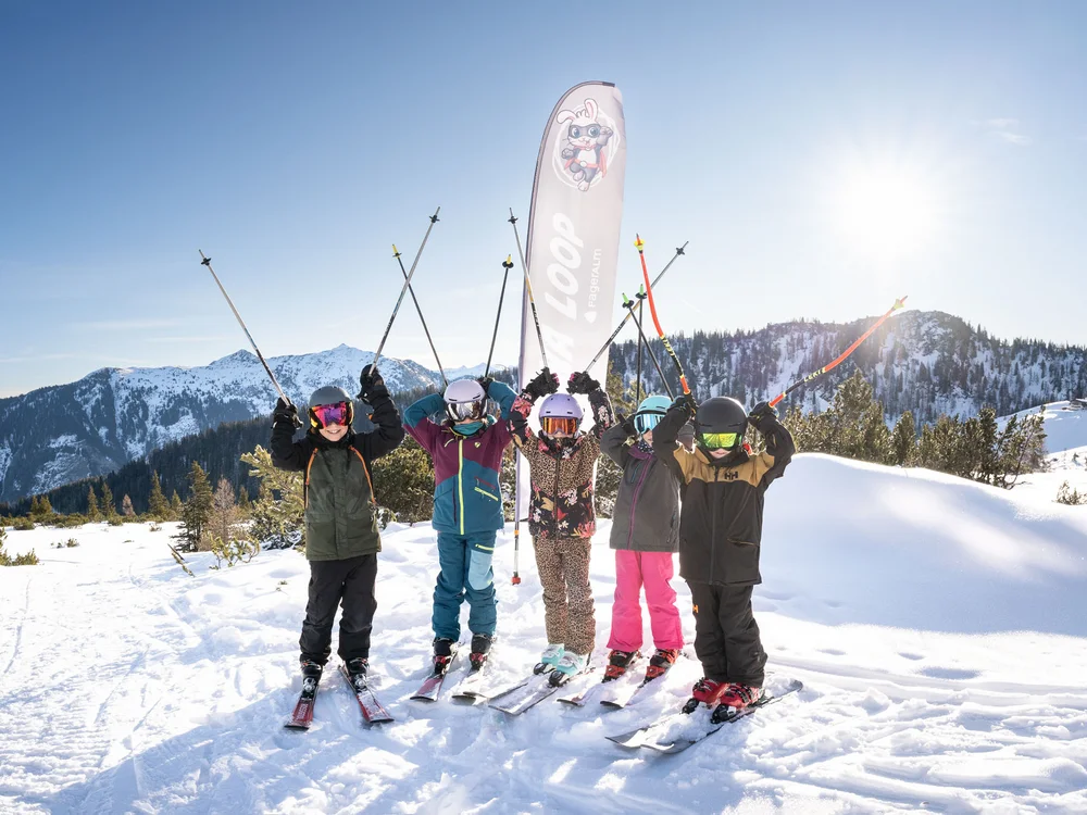 Winterurlaub beim Forstauerwirt Sechs Skifahrer jubeln mit erhobenen Skistöcken vor einer verschneiten Bergkulisse