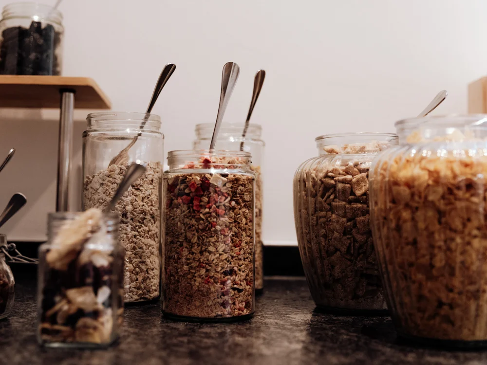 Winterurlaub beim Forstauerwirt Gläser mit Müsli und verschiedenen Cerealien, jeweils mit einem Löffel